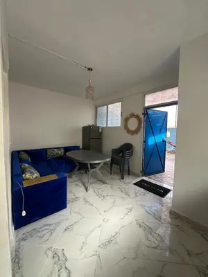 a living room with a blue couch and a table at A unique and cute apartment in a prime location in Er Rachidia