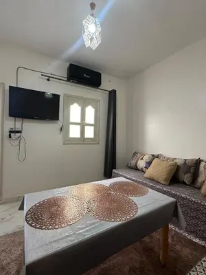 a living room with a table and a couch at A unique and cute apartment in a prime location in Er Rachidia