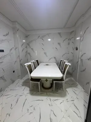 a white table and chairs in a room with marble walls at Calm Elegant Apartment City Center with Garage in Fès