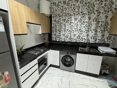 a kitchen with a washer and a washing machine at Calm Elegant Apartment City Center with Garage in Fès