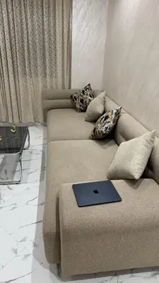 a living room with a couch with a laptop on it at Calm Elegant Apartment City Center with Garage in Fès