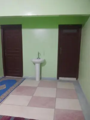 a bathroom with two doors and a sink at Maison La Baraka Merzouga in Merzouga