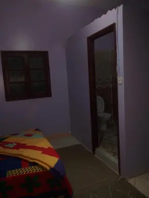 a room with a bathroom with a toilet and a bed at Maison La Baraka Merzouga in Merzouga