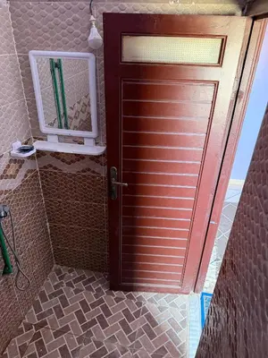 a door in a bathroom with a mirror next to it at Maison La Baraka Merzouga in Merzouga
