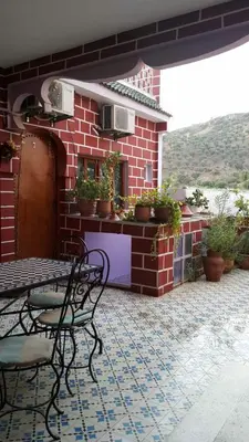a patio with a table and chairs on a brick building at Kasabah Senhaji in Moulay Idriss Zerhoun