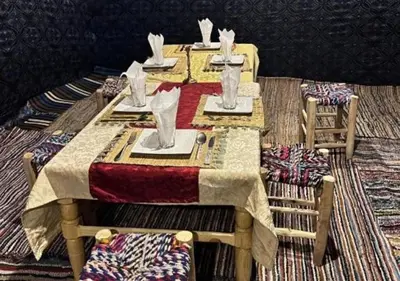 a table with plates and napkins on top at Merzouga Camping Sahara in Hassilabied