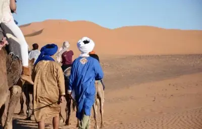 a group of people walking in the desert at Merzouga Camping Sahara in Hassilabied