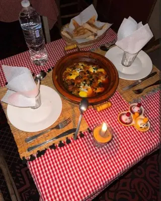 a table with a plate of food on a table at Merzouga Camping Sahara in Hassilabied