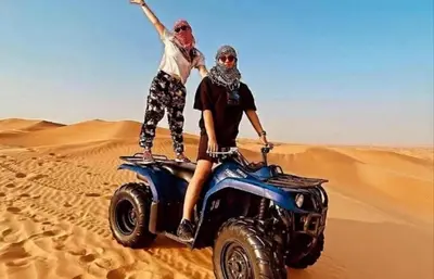 two people standing on a atv in the desert at Merzouga Camping Sahara in Hassilabied
