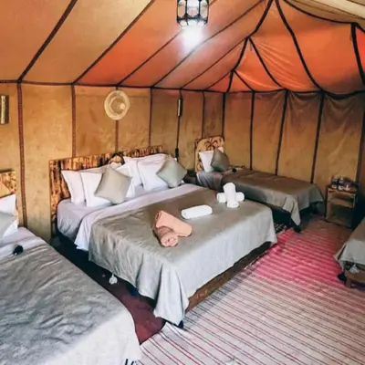 a bedroom with two beds in a tent at Merzouga Hero luxury Glamping in Merzouga