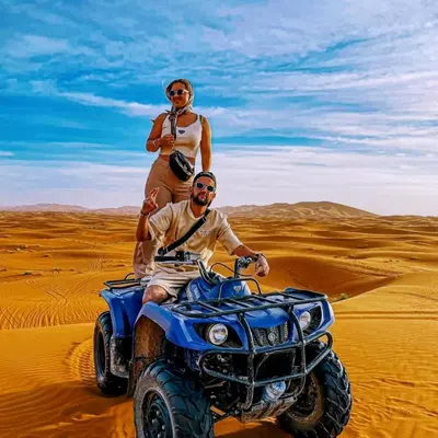 two men standing on a dirt bike in the desert at Merzouga Hero luxury Glamping in Merzouga