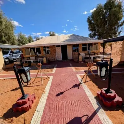 a building with a table and benches in the dirt at Merzouga Hero luxury Glamping in Merzouga