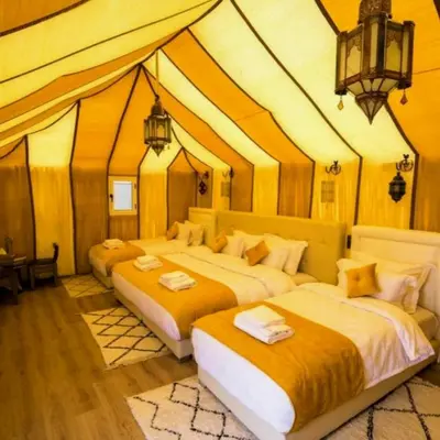 two beds in a room with a tent at Merzouga Hero luxury Glamping in Merzouga