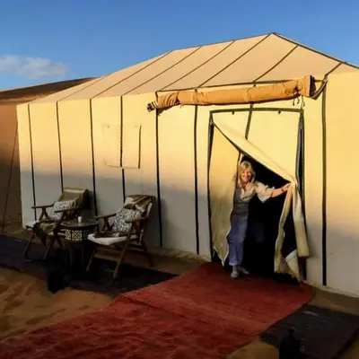 a woman is standing inside of a tent at Merzouga Hero luxury Glamping in Merzouga