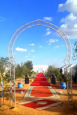 a red carpetllor with an arch in a park at Sahara Waves Luxury Camp in Merzouga
