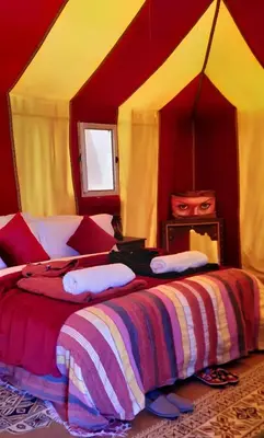 a bedroom with a large bed in a tent at Sahara Waves Luxury Camp in Merzouga