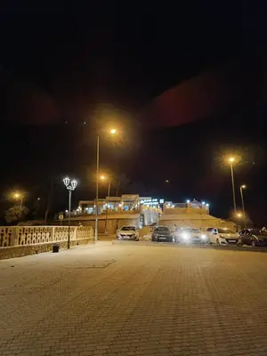 a parking lot at night with cars parked at Afraklie Camp in Merzouga