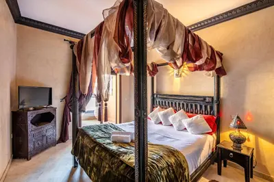 a bedroom with a canopy bed and a television at Luxury Suite charming and comfortable in Oulad Akkou