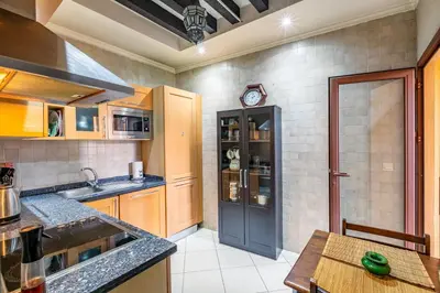 a kitchen with wooden cabinets and a clock on the wall at Luxury Suite charming and comfortable in Oulad Akkou