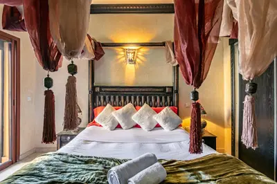 a bedroom with a large bed with red curtains at Luxury Suite charming and comfortable in Oulad Akkou