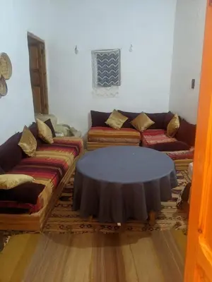 a living room with a couch and a table at Chez Noureddine L 'GARAH in Kermets