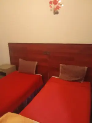 two beds sitting next to each other in a room at Hôtel monument historique situé au centre de la ville in Azrou