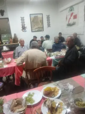 a group of people sitting at tables with plates of food at Hôtel monument historique situé au centre de la ville in Azrou