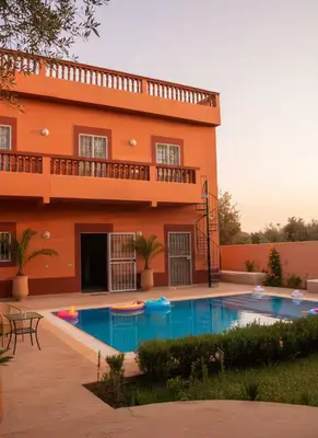 a building with a swimming pool in front of a house at Dar Atlas, Piscine & Jacuzzi Sans Vis-à-Vis in Sbiti