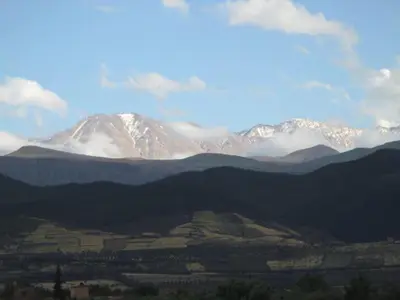 a snow covered mountain in the middle of a valley at Dar Atlas, Piscine & Jacuzzi Sans Vis-à-Vis in Sbiti