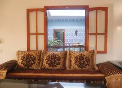 a couch with pillows sitting in a living room at Dar Atlas, Piscine & Jacuzzi Sans Vis-à-Vis in Sbiti