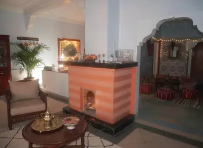 a living room with a fireplace and a table at Dar Atlas, Piscine & Jacuzzi Sans Vis-à-Vis in Sbiti