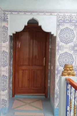 a wooden door in a room with a wall at Dar Atlas, Piscine & Jacuzzi Sans Vis-à-Vis in Sbiti