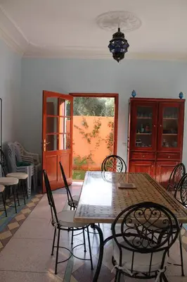 a dining room with a table and chairs at Dar Atlas, Piscine & Jacuzzi Sans Vis-à-Vis in Sbiti