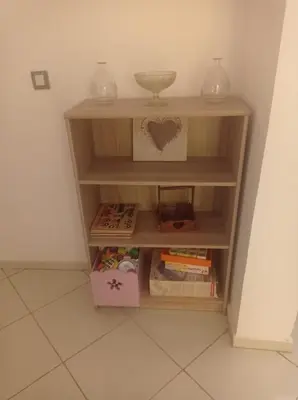 a book shelf in a corner with books at appartement neuf au premier etage in Fès
