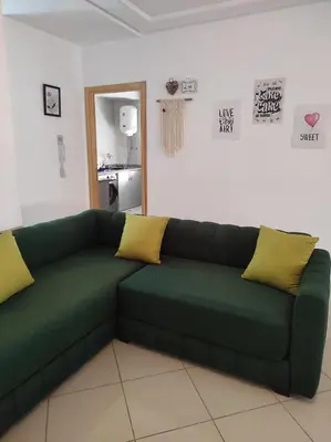 a green couch with yellow pillows in a living room at rdc surélevé neuf a 10 min du centre ville in Fès
