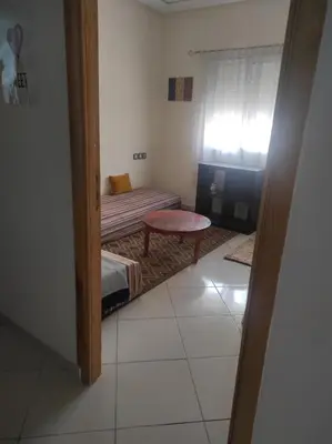 a small room with a bed and a bench and a window at rdc surélevé neuf a 10 min du centre ville in Fès