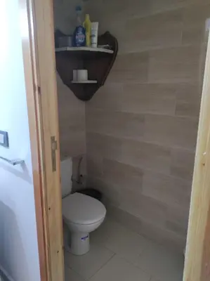 a small bathroom with a toilet and a shelf at rdc surélevé neuf a 10 min du centre ville in Fès