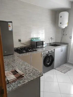 a kitchen with a stove and a washing machine at rdc surélevé neuf a 10 min du centre ville in Fès