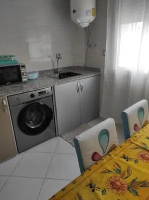 a kitchen with a washing machine and a table at rdc surélevé neuf a 10 min du centre ville in Fès