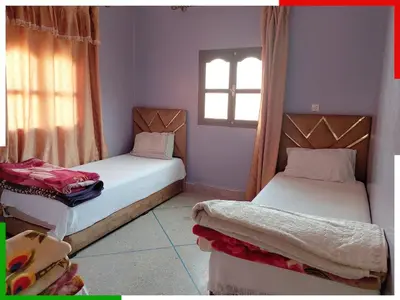 two beds in a small room with a window at Spacious apartment for families near Ouzoud Falls in Azilal