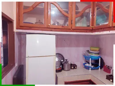 a kitchen with a white refrigerator and wooden cabinets at Spacious apartment for families near Ouzoud Falls in Azilal