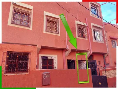 a building with a green arrow in front of it at Spacious apartment for families near Ouzoud Falls in Azilal