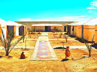 a row of tents in the middle of the desert at Tigmi Desert Camp in Merzouga
