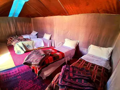 a room with two beds in a small room at Tigmi Desert Camp in Merzouga