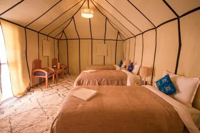 a room with three beds in a tent at Avatar Luxe Camp in Merzouga