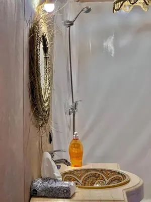 a bathroom with a sink with a shower and a mirror at Avatar Luxe Camp in Merzouga