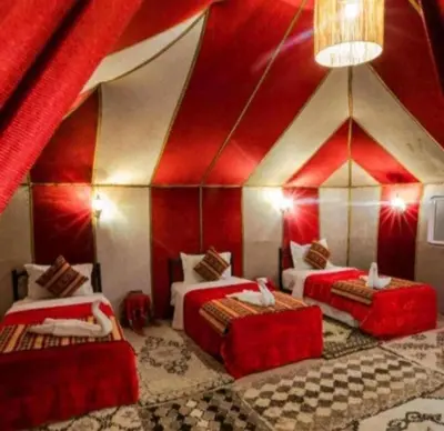 a room with two beds in a red and white tent at Avatar Luxe Camp in Merzouga
