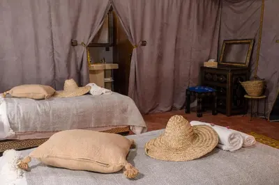 two beds with hats on top of them in a room at Avatar Luxe Camp in Merzouga