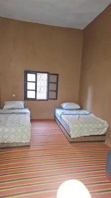 a bedroom with two beds and a window at Dar salam in Mhamid