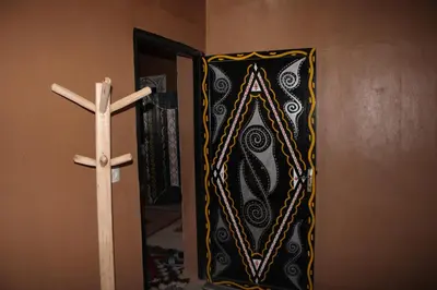 a cross hanging on a wall next to a door at Dar salam in Mhamid
